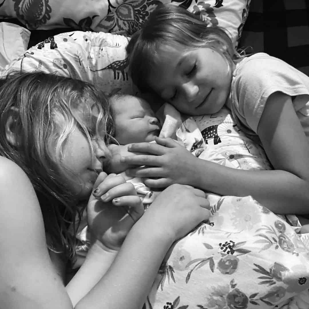 how to bond with your baby older siblings cradling newborn baby bonding